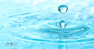 Hands blessing water with light, love, freedom and joy, awakening its sacred properties
